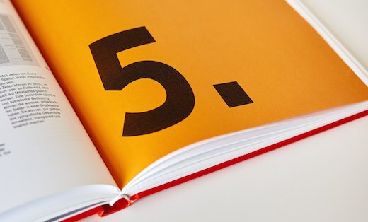 Bold black number five on an orange book page