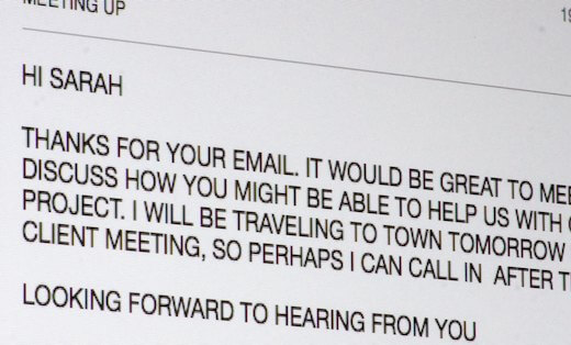 A computer screen showing a business email written in all capitals