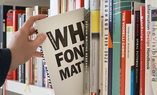 Why Fonts Matter book being taken off a bookcase full of design books