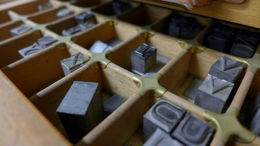 Movable metal type in a type tray