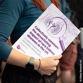 A person with a copy of Kidney Research UK's Collectively common: the devastating impact of rare kidney diseases report front tucked under their arm