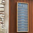 The full door sign at The Gentle Touch: grey laminate with an oak frame and blue and white writing